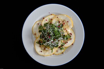 Angerichtete, leckere Vorspeise mit Scheiben einer Zitronatszitrone, auch Cedro genannt, Rucola, rosa Beeren, Parmesankäse und einer Vinaigrette