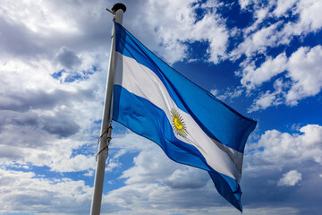 Argentina flag waving against blue cloudy sky