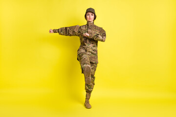 Full length photo of pretty calm lady marching look focused camera isolated on yellow color background