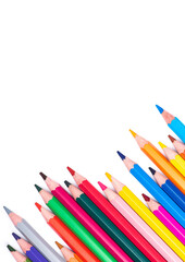 vertical photograph of bright colored pencils isolated on white background in a staggered row diagonally from bottom corner with copy space.