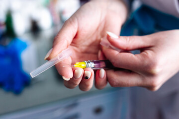 Female hands with a syringe for injection. Vaccination.