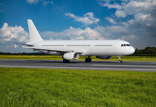 Travel image of a big white passenger airplane on a runway before takeoff in summer