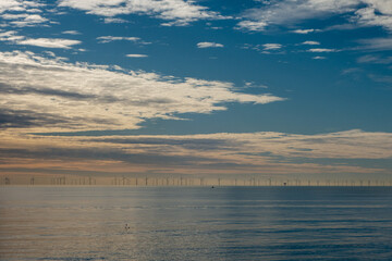 Obraz premium Rampion Wind Farm on the horizon visible from the beach at Brighton.