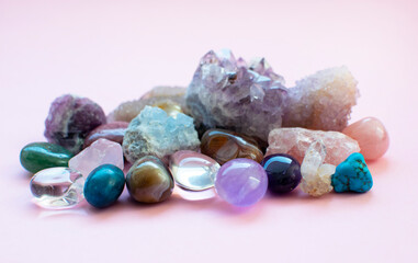 Tumbled and rough gemstones and crystals of various colors. Amethyst, rose quartz, agate, apatite, aventurine, olivine, turquoise, aquamarine, rock crystal. Selective focus.