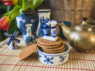 Traditional Dutch stroopwafel and typical Dutch blue porcelain. Figurines of kissing boy and girl and windmill.