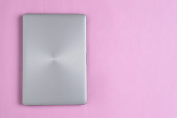 Flat Lay of minimalist silver laptop with copy space on pink