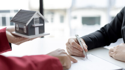 Signing a home purchase contract, sales manager has proposed terms and conditions to customers who sign house purchase agreements with insurance, Agreement to sign the purchase contract concept.