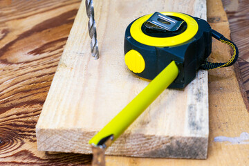 measuring tape on the board and drill drilling board concept repair construction