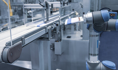 Automated robotic arm load aluminum cosmetic tube to filling machine in production line