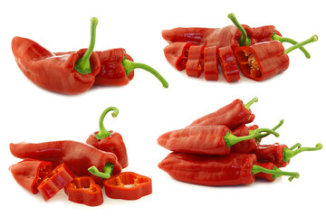 freshly red sweet peppers and some cut ones (capsicum) on a white background