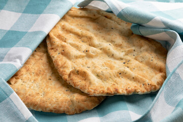 Traditional fresh baked naan with garlic and coriander in a cloth to keep fresh close up 