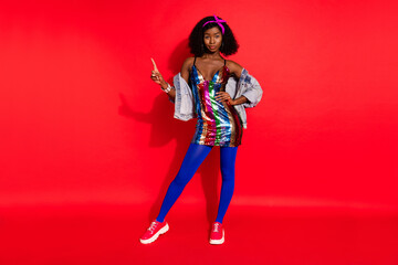 Obraz premium Photo of pretty adorable wavy dark skin lady wear pin up outfit pointing finger empty space isolated red color background