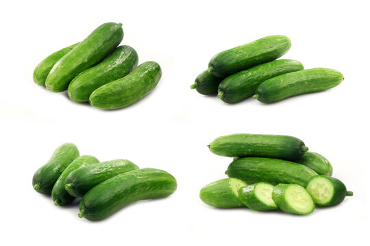 fresh green baby cucumbers you can eat as a snack and some cut ones on a white background