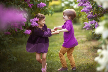 Funne twins boy and girl in spring garden - 424776024