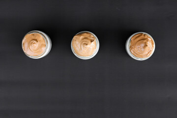 Desert line of coffee jars. Coffee jars with chocolate. Black background. 