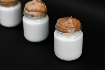 Small coffee jars filled witrh milk and cream. Homemade dalgona coffee. Coffee desert.