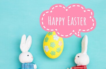 Happy easter greeting card idea, Beautiful design yellow easter egg on blurred blue background with white rabbit