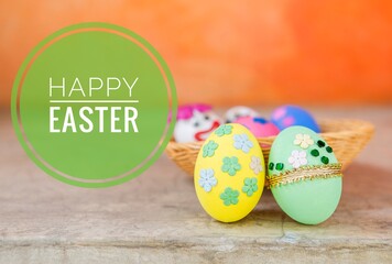Happy easter card background idea, Beautiful easter egg decorate with paper flower and gold ribbon and green glass over blurred orange wall background