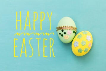 Happy Easter, Beautiful green and yellow Easter egg on blue texture background, handmade easter egg, craft object, greeting card background idea