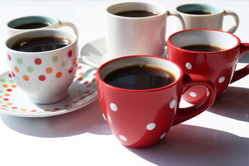 Set of different coffee cups with espresso on white table background. Hard light, shadow. Summer still life. 
