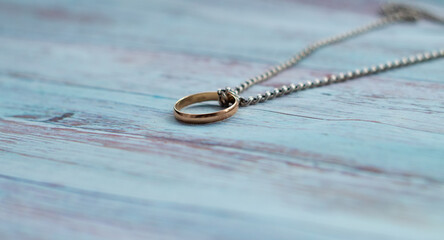 silver chain and ring on wooden background