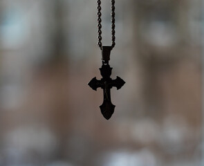 silver chain and cross, close-up with blurred background