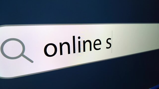 Online shopping written in search bar with cursor, computer monitor, close-up with camera zoom effect. 4k