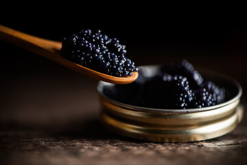 Black lumpfish caviar in a small pot and spoon - 424784021