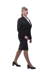 Front view of business woman is walking. She is smiling and looking at the camera