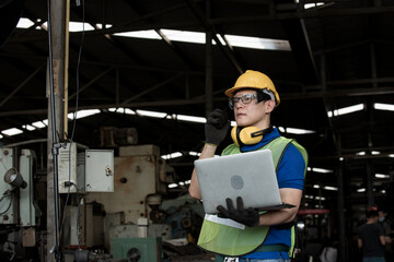 worker  working in steel industrial with uniform.  worker with computer laptop in hand hold.