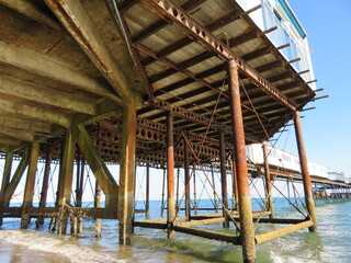 View of underside of wooden and steel pier on the beach