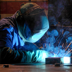 industry - worker in action with face shield, overalls and gloves
