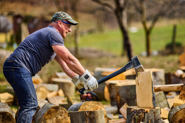 strong man splitting beech logs with an ax