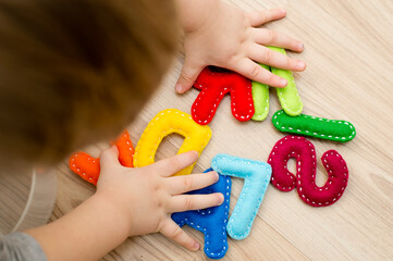 Two year boy dialing his name from felt letters. Learning to read.