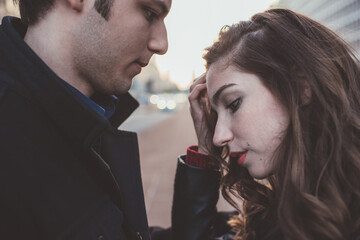 Two young beautiful caucasian couple outdoor looking in the eye romantic