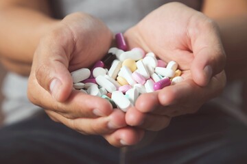 A wide variety of medicines pills and capsules were in the hands of young men.health care concept.