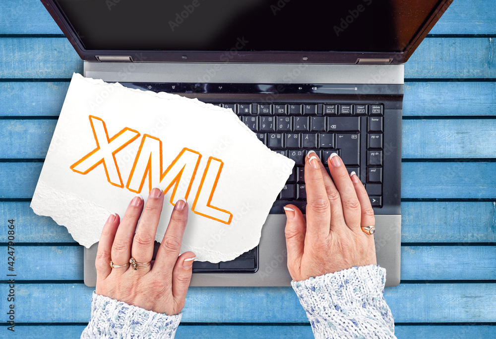 Poster extensible markup language. word xml on paper with hands and laptop