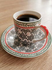 Image of a cup of black coffee on a wooden table