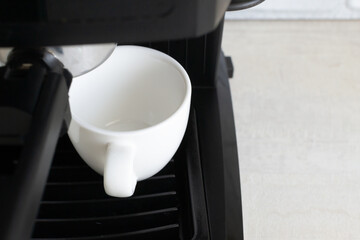 Black coffee machine and two white espresso cups. Homemade coffee making concept. Horizontal orientation. Close-up.