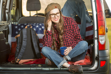 Happy traveler in a car with american flag