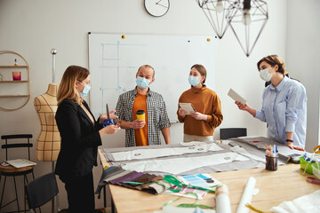 Clothes designer explaining students the cutting process