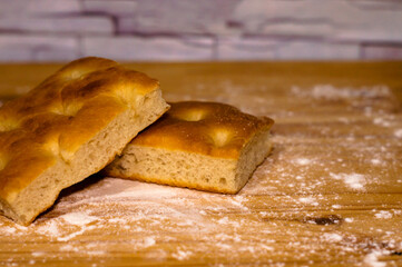 Italian Focaccia bread on a table with flour