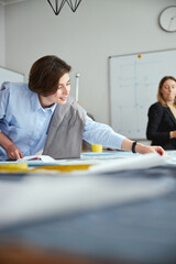 Obraz premium Female clothes design student using tape measure