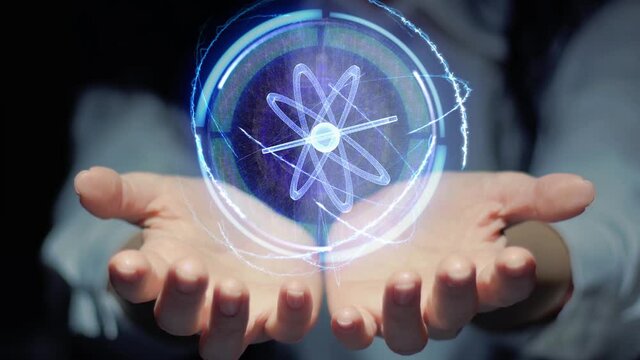 Female hands show a round conceptual hologram with atom molecular structure. Unrecognizable woman in ashen white on a black background with future holographic technology