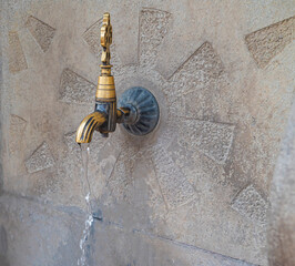 Close up of an antique Turkish faucet in the garden. Old, historical water tap on the wall.