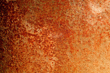 Rusty red sheet of metal lit by sunlight.
