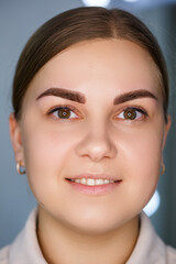 Obraz premium A close-up of the face of a young woman who has just had a permanent eyebrow tattoo done.
