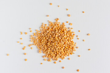 Closeup of heap of yellow chana split peas isolated against white