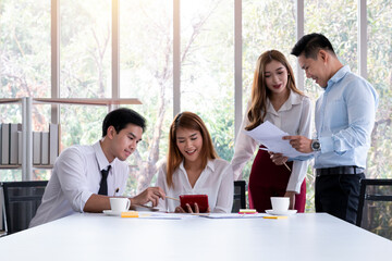 Group of young business people working and communicating while sitting at the office desk together. Young team of coworkers making great business discussion. 
