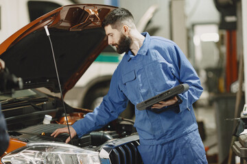 Checking car for serviceability in garage with tools on rise